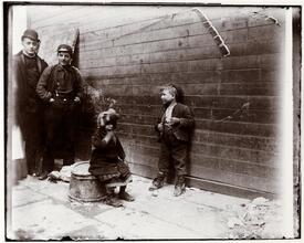 Two Greek children in Gotham Court debating if Santa Claus will get to their alley or not. He did.