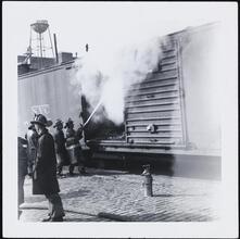 [Firemen putting out a fire in a train car.]