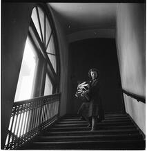 Columbia University [Woman with a large stack of books walking down a flight of stairs.]