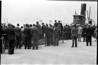 [People waiting on the dock of the Hoboken Ferry Terminal.]