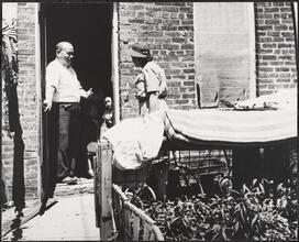 Henry Street Visiting Nurse Service, Rear of Chinese Hand Laundry, Father Greeting Nurse on a Routine Visit to See his Child.