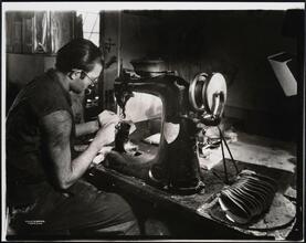 Interior, shoe factory with man at machine