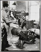 Interior, shoe factory with man at machine
