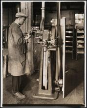 Interior, shoe factory with man at machine
