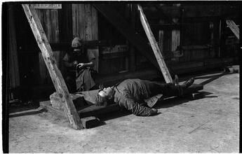 [Destitute man sleeping outside.]