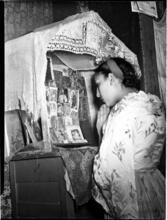 [Woman praying at an altar.]