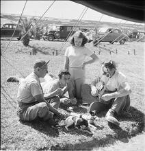 Circus [Group playing cards, one is dressed like a clown.]