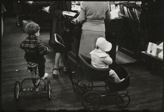 The 5 and 10 [Boy on tricycle and a child in a stroller at Woolworth's.]