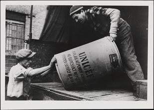 [Men unloading UNICEF food cans in Hungary.]