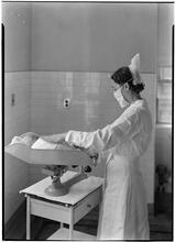 Beth Israel Hospital, Stuyvesant Square. Nurse weighing infant.