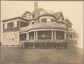 [Group of men in front of a house.]