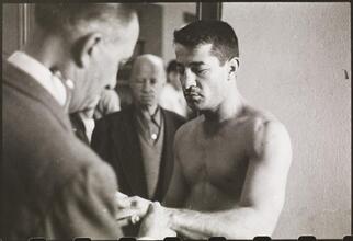 Rocky Graziano, He's a Good Boy Now [Man examining Rocky Graziano's hand.]