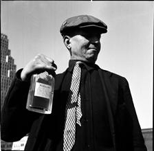 Waterfront. [Man a holding a bottle of denatured alcohol marked "Poison".]