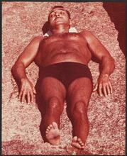 Untitled [Man sleeping on the beach of Coney Island.]