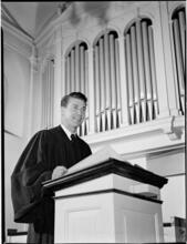 [Priest at a pulpit.]