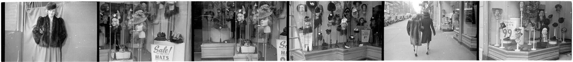 [Hat displays in store window and two women walking down city street.]