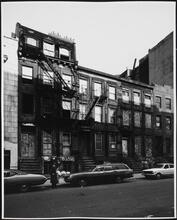 [Boarded up row houses on the north side of East 7th Street, near the corner of Avenue C.]