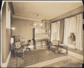 [Interior, room with wicker chairs and telephones.]