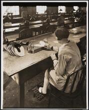 Interior, shoe factory with woman at machine