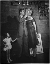 [Jack Carson kissing another performer during an autograph session.]