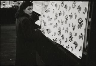 The 5 and 10 [Woman looking at fabric at Woolworth's.]