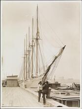 [Men standing on dock near ship.]