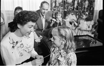 Deaf Children [Teacher helping child with her hearing aid.]