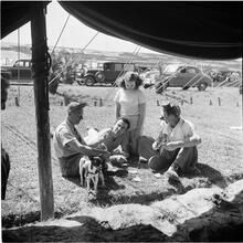 Circus [Group of people playing cards, one is dressed like a clown.]