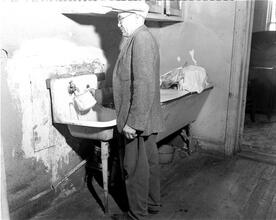 Man Filling Pitcher at Sink