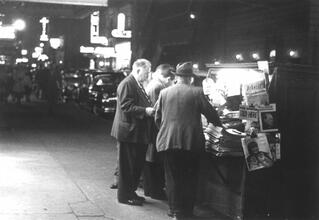 Untitled [Men at Newsstand, nighttime]
