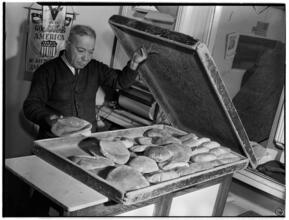 [Man displaying bread.]