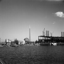 [Construction of the New York World's Fair site, with the steel frames of the Trylon and Perisphere in the background.]