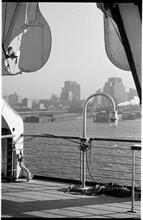 [View of waterfront activity along the Hudson River from deck of ship.]