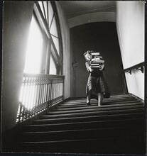 Columbia University [Women carrying large stack of books down stairs.]