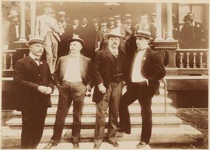 [Theodore Roosevelt with other men on a porch.]
