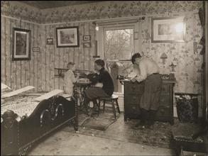 [Bedroom with three boys working on projects.]