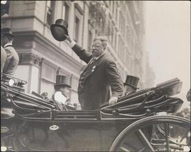 [Teddy Roosevelt waves to the crowd at a parade in his honor.]