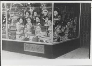 [Women's hats displayed in store window.]