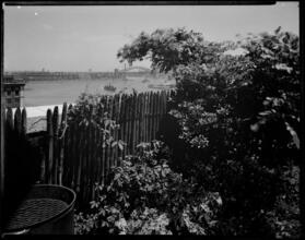 [View from a yard with the Hell Gate Bridge in the background.]