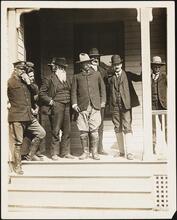 [Theodore Roosevelt and other men on a porch.]