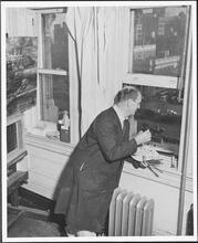 [Reginald Marsh looking out of a window.]