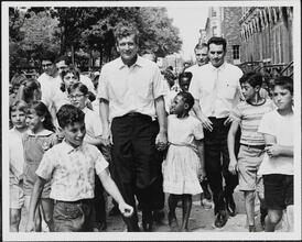 [John V. Lindsay walking down the street with a group of children.]