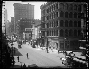 Broadway Series. View of west side of Bway looking south from Howard St. Fall River Cotton Exchange on corner at right. Canal Street in the middle distance shows the advertising sign of John Drinkwate
