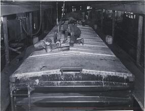 [Men completing manufacturing of a train.]