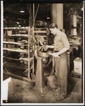 Interior, shoe factory with man at machine