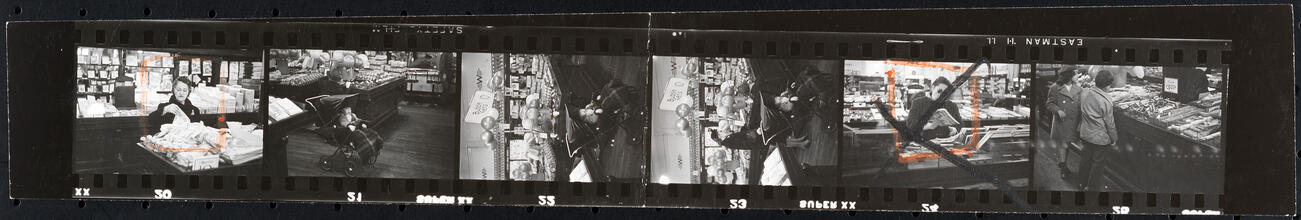 The 5 and 10 [People shopping and a child in a stroller at Woolworth's.]