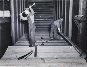 [Men manufacturing railroad cars.]