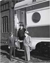 [Men outside railroad car.]