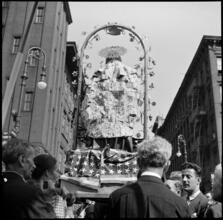 [Religious statue covered in money at an Italian street fair.]