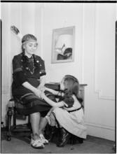 [Woman in Native American attire with girl.]